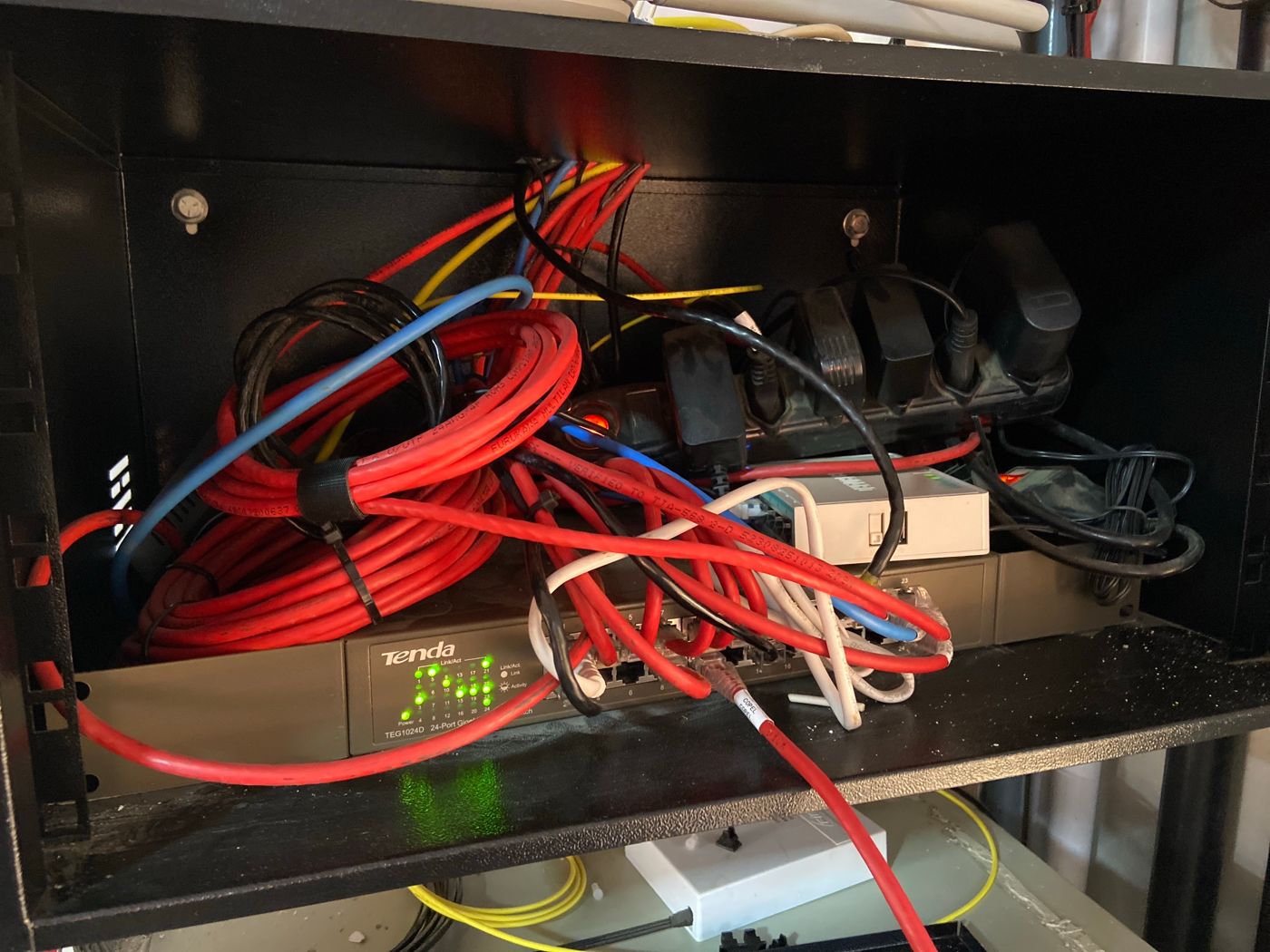 Rack com cabos embolados e régua de energia solta