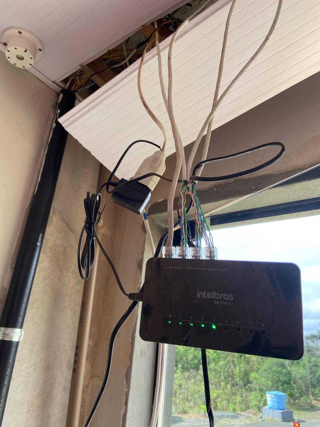 Switch pendurado no ar com cabos sem acabamento