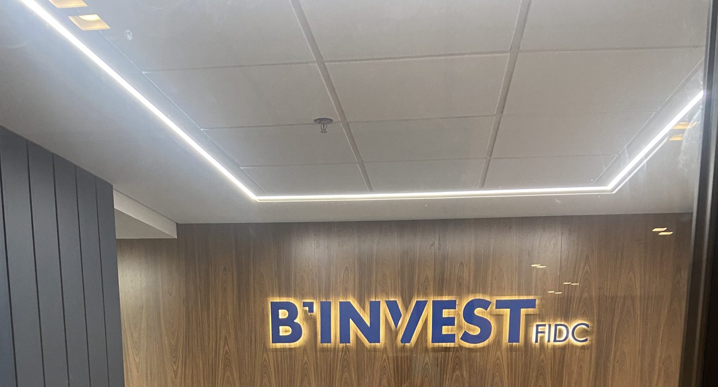 Recepção da B'Invest FIDC com letreiro iluminado, em Curitiba (PR)