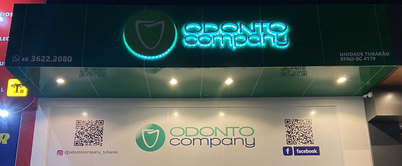 Fachada da Odonto Company, unidade Tubarão (SC), com letreiro iluminado